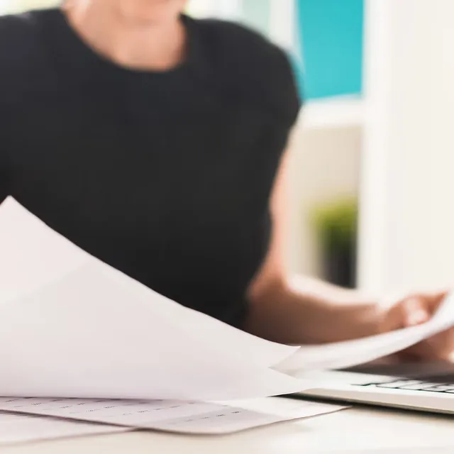 Documents and a laptop on a desk